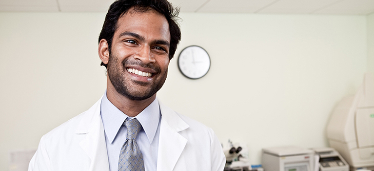 Doctor smiling and holding tablet